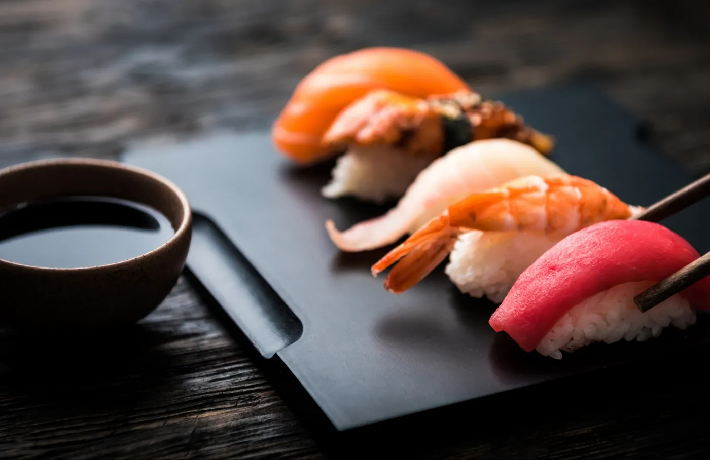 Assorted nigiri sushi set on black slate tray at Sucré d’Amour Café & Sushi, a Sushi Restaurant in Fremont